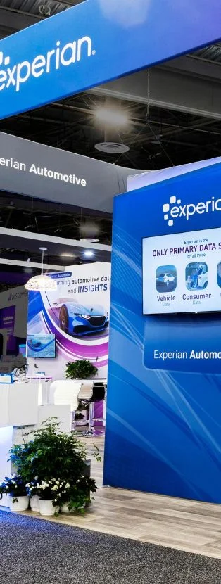 Experian trade show display with backlit walls, clean architecture, and overhead branding