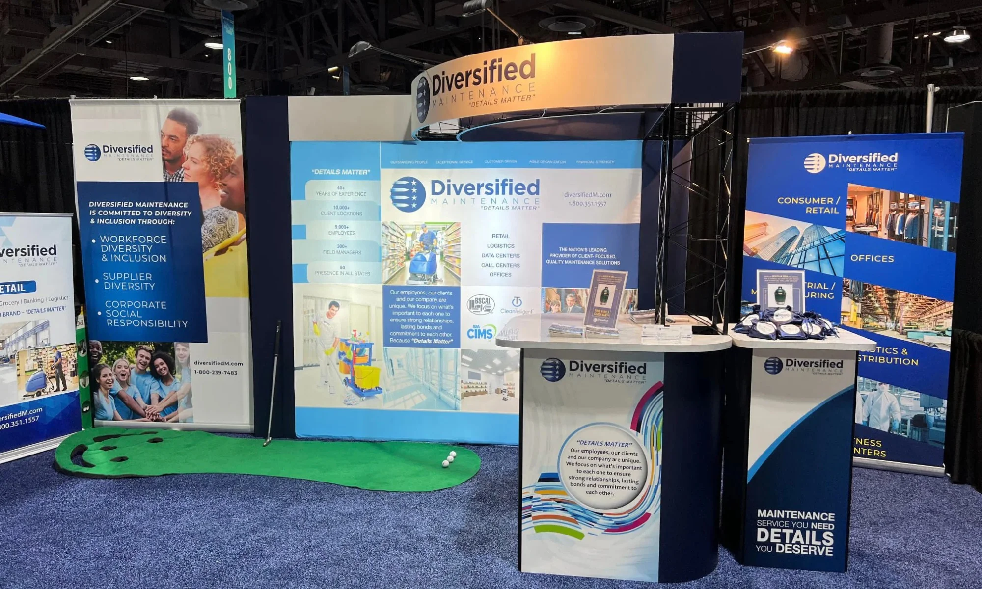 Diversified Maintenance trade show booth with curved header, branded panels, counters, and mini putting green by Suncoast Displays