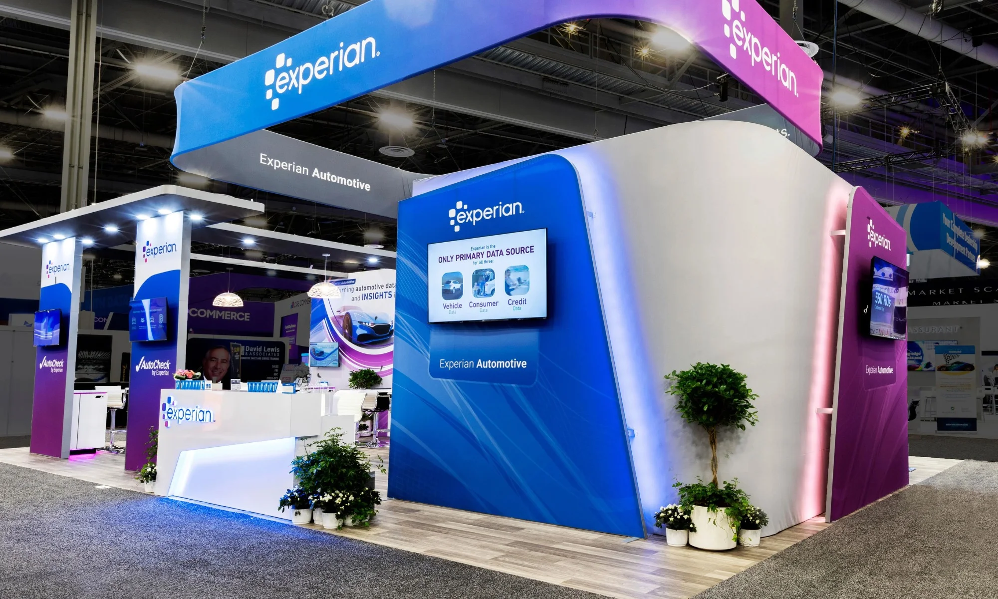 Experian Automotive trade show display with curved LED wall, illuminated counters, and branded graphics by Suncoast Displays
