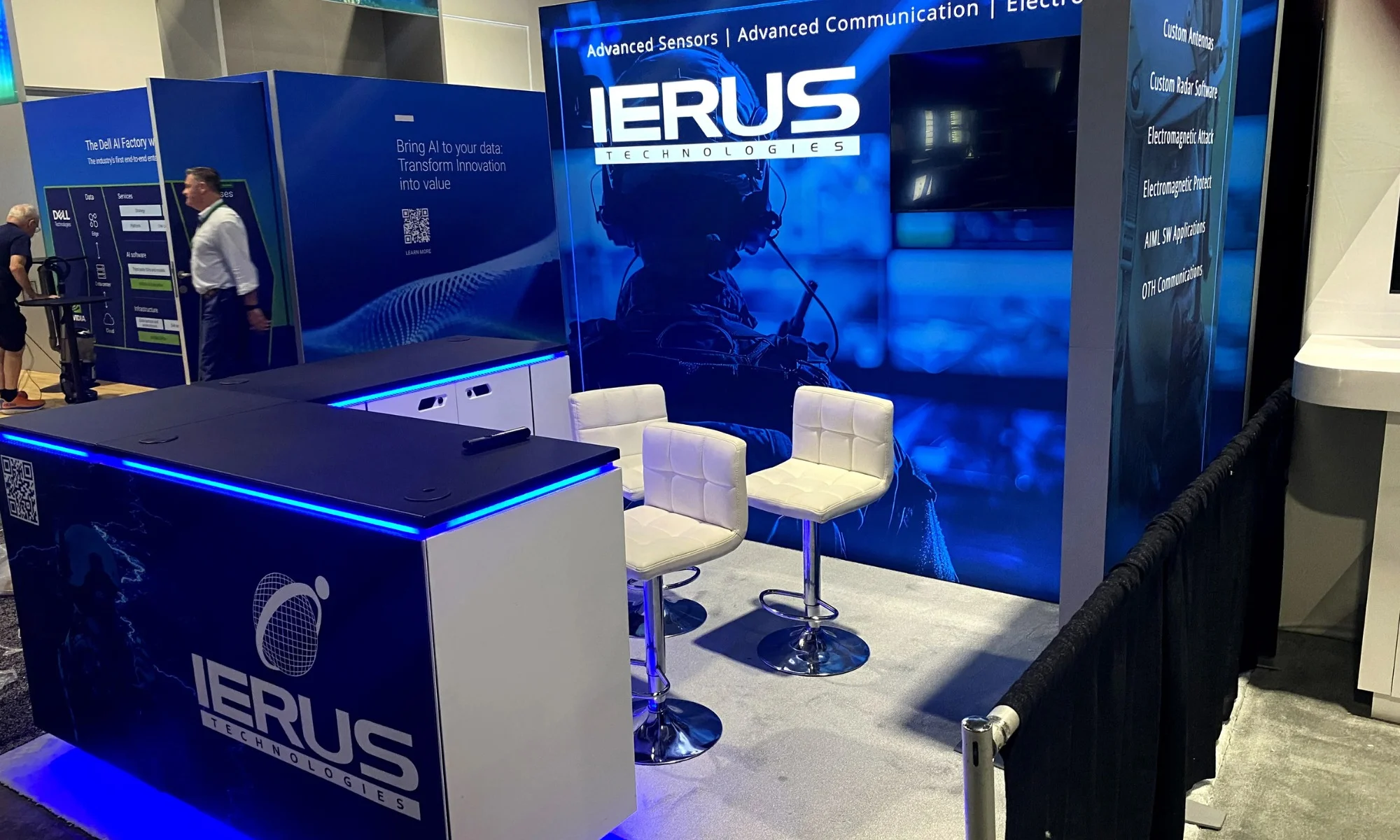 IERUS Technologies trade show display with blue illuminated counters, video wall, and branded graphics by Suncoast Displays