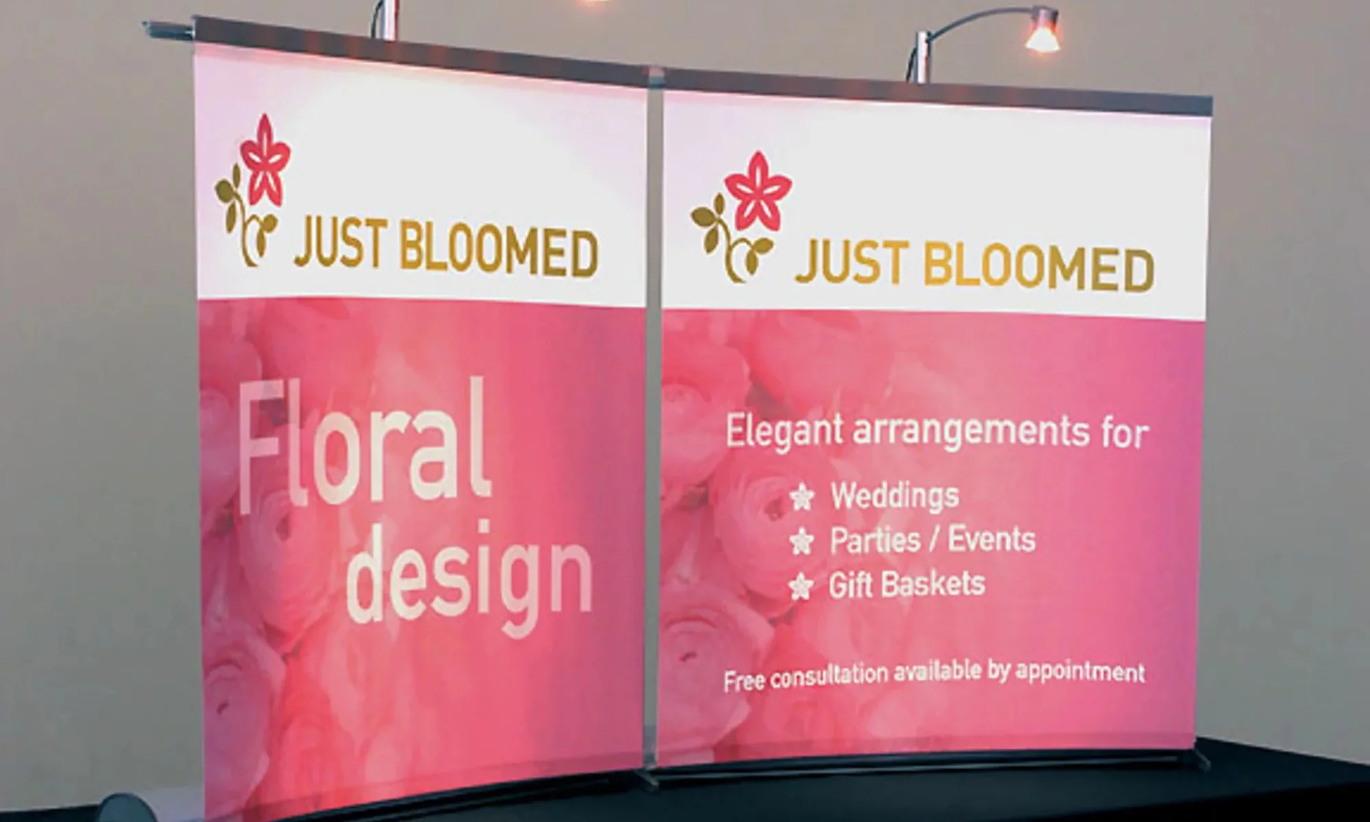 Just Bloomed trade show display with pink floral graphics and curved panels by Suncoast Displays