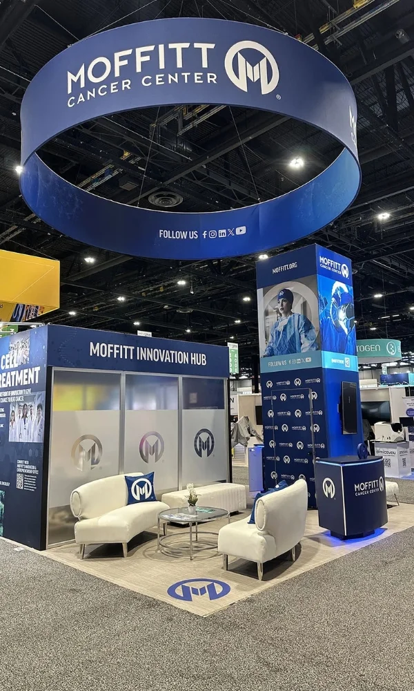 Moffitt Cancer Center trade show booth with circular hanging sign, lounge seating, and innovation hub display by Suncoast Displays