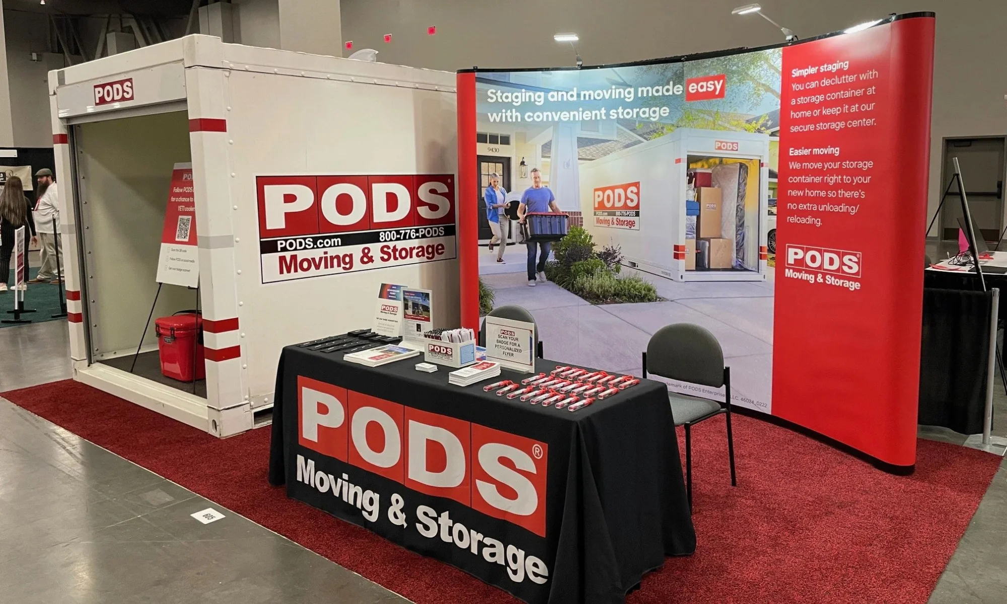 PODS trade show booth with real container, curved graphic backwall, and branded demo table by Suncoast Displays